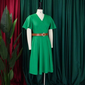 Detail of V-neck green dress with ruffled sleeves and brown faux leather belt