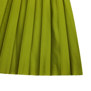Dettaglio della trama del tessuto plissettato verde lime con pieghe verticali e finitura