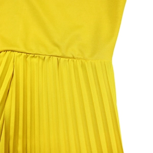 Gros plan du tissu plissé jaune montrant les plis fins et les détails de la couture
