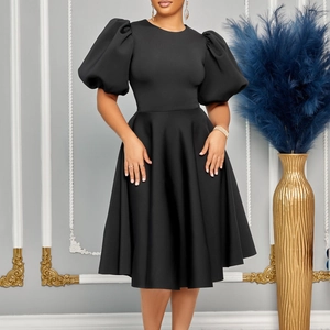 Détail de robe noire trapèze élégante avec manches bouffantes et une taille ajustée