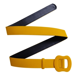 Détail de la ceinture en daim ocre avec boucle carrée recouverte de tissu