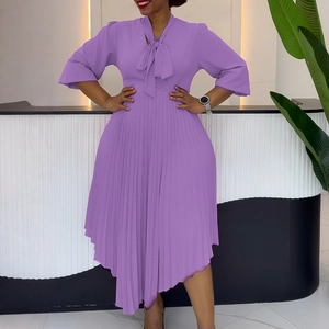 Detail of purple pleated dress featuring a tie-up bow neckline and ruffled flare sleeves