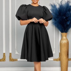 Détail d'une élégante robe midi noire avec manches bouffantes et une encolure ronde chic