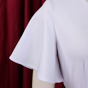Detailed macro shot of white textured fabric and ruffled bell sleeve on women's dress
