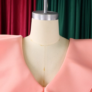Close-up of deep V-neckline and structured shoulder detail on pink fishtail dress