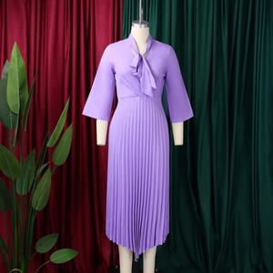 Detailed view of the purple midi dress with pussy-bow neck and pleated irregular hemline