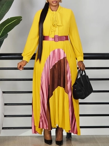 Elegant yellow long-sleeved pleated dress with contrast bow belt and patchwork hem