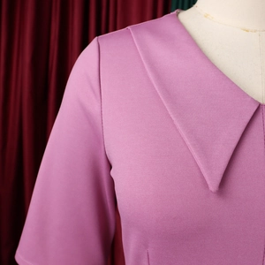 Dettaglio dell'elegante scollo a V color malva con ampio colletto e tessuto a maglia