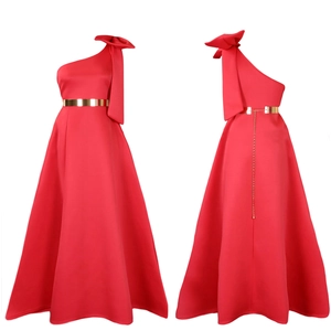 Detail of red one-shoulder gown with oversized bow and golden metal belt with chain
