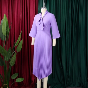 Detail of elegant purple pleated dress with V-neck bow tie and delicate chiffon texture