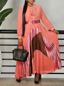 Elegant long sleeve pleated dress in coral pink with color block hem and tie neckline