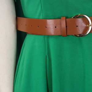 Close-up of green dress waist with brown leather belt and gold circular buckle detail