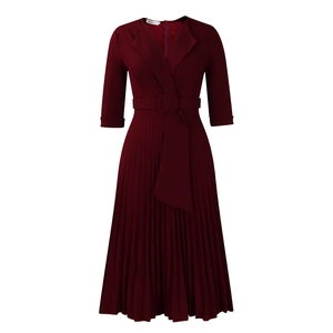 Détail d'une robe plissée bordeaux avec col tailleur et ceinture assortie à la taille