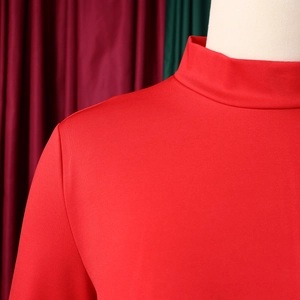 Detail of red mock neck knit dress with refined texture and close-up tailoring details