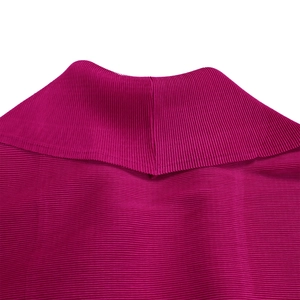 Dettaglio della maglia a pieghe magenta con collo alto e texture increspata fine