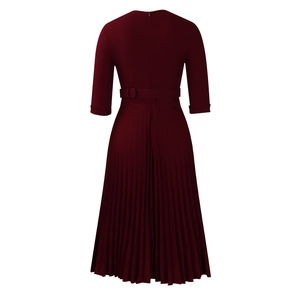 Détail d'une robe plissée bordeaux montrant la taille cintrée et la ceinture au dos