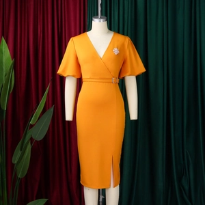 Detail eines orangen V-Ausschnitt Kleides mit Puffärmeln, Gürtel und Brosche