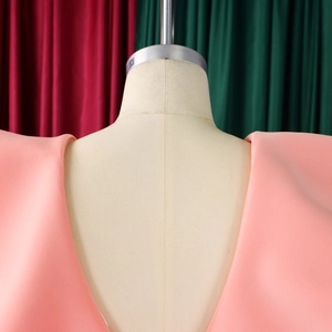 Close-up of pink V-neck dress shoulder details and premium woven fabric on a mannequin