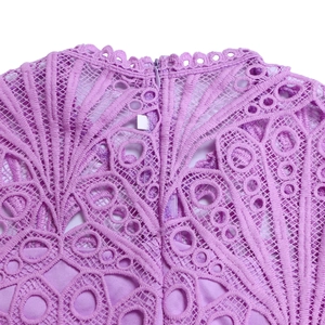 Macro detail of violet lace dress featuring hollow-out floral patterns and invisible zipper