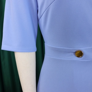 Detail of light purple dress showing middle sleeve and gold button on waist seam
