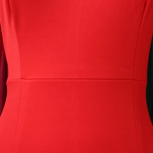 Detailed view of the red dress showing the high-waisted seam and textured knit fabric