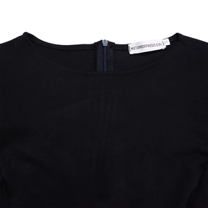 Detail of round neckline with hidden back zipper and brand label on black dress
