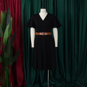 Detail of black V-neck wrap dress with brown leather belt and ruffled sleeves on mannequin