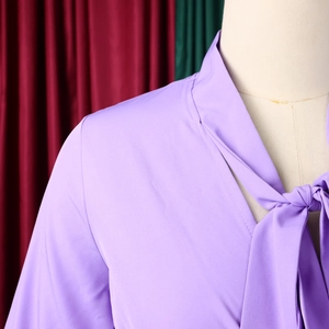 Close-up of elegant lavender V-neck dress with adjustable bow tie and pleated fabric detail