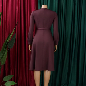 Detail view of burgundy long sleeve dress featuring an invisible back zipper and belted waist