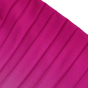 Vista macro del tessuto plissettato magenta con trama liscia e finitura lucida
