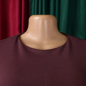 Close-up of elegant dark purple long sleeve dress fabric and round neckline detail