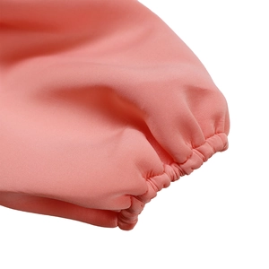 Détail des poignets élastiques de la robe de soirée rose montrant la texture fine