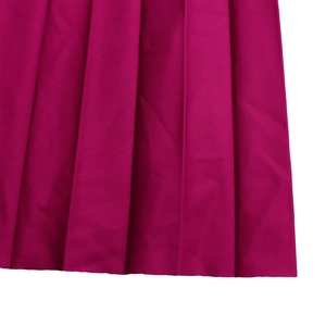 Dettaglio gonna a pieghe rosa fucsia con pieghe verticali e cuciture sull'orlo pulite