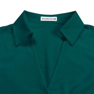 Detail of elegant dark green pleated dress showing V-neckline and notched lapel texture