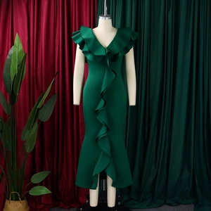 Deep green V-neck dress detail showing ruffles and high-quality glossy fabric