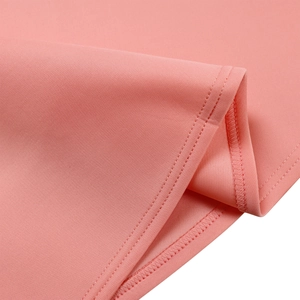 Détail de l'ourlet de robe rose pêche avec double couture précise et finition intérieure nette