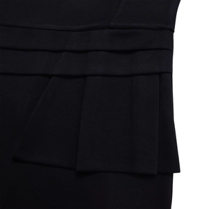 Detail view of refined multi-layered pleats on a black OL dress with texture