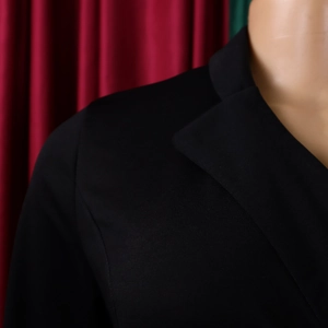 Detail des eleganten schwarzen Business-Kleides mit Reverskragen und feiner Textur