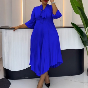 Detailed view of royal blue pleated dress featuring bow tie neck and three-quarter sleeves