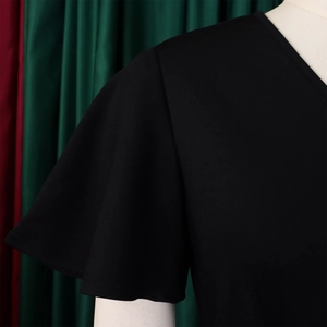 Close-up of elegant V-neck and ruffled flare sleeves on a black African style dress