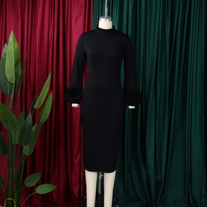 Detail of elegant ruffled cuffs on this slim fit black midi dress with a high neckline