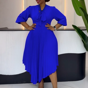 Detail of royal blue pleated dress featuring bow tie neckline and flared sleeves