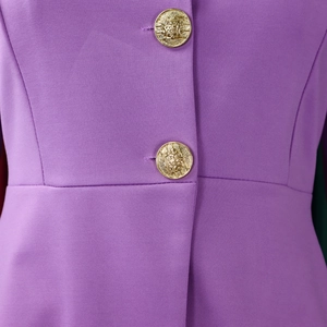 Detail of purple woven fabric with decorative golden embossed vintage buttons