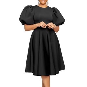 Détail de la robe noire élégante montrant le tissu texturé et le col rond classique