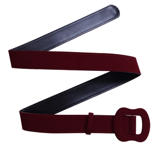 Détail de la ceinture large en daim bordeaux avec boucle ondulée et finition mate élégante