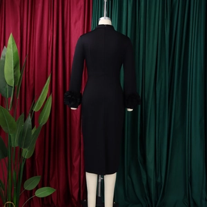 Detail of elegant black dress showing high neck and 3D floral accents on cuffs