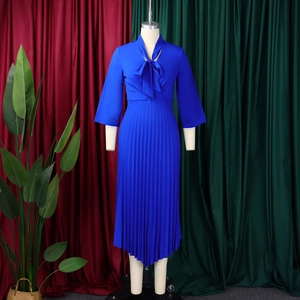 Detail of elegant royal blue satin dress featuring accordion pleats and a V-neck bow