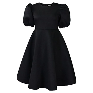 Détail d'une robe noire évasée à col rond avec manches bouffantes et taille cintrée