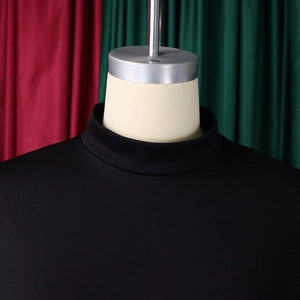 Close-up of elegant black mock neck dress showing fabric texture and shoulder stitching