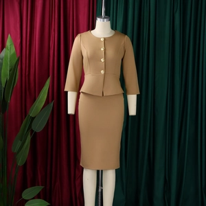 Detail of camel peplum business set featuring elegant golden buttons and crew neck